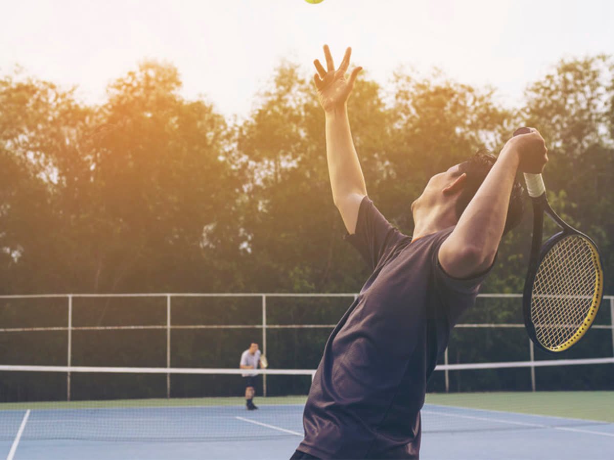 Persona jugando tenis en una cancha